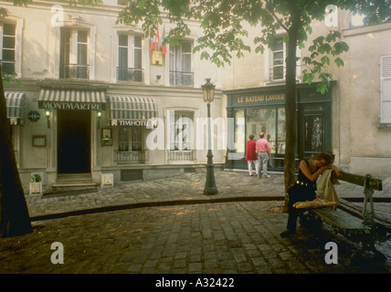 Paar Schaufensterbummel auf Straße in Paris Frankreich Frau sitzen auf Bank mit baguettes Stockfoto