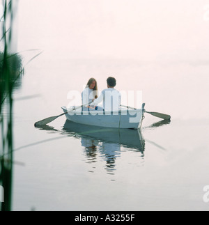 Ein Teenager-Jungen und Mädchen nehmen eine romantische Fahrt auf dem Wasser in einem Ruderboot Stockfoto