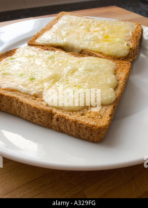 Käse schmelzen schmolz auf braun Toast Vollkornbrot auf einer Platte Grill heiß gegrillt Stockfoto