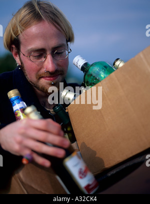 Person in den Zwanzigern recycling Bierflaschen Recycling Einheit North Wales UK Stockfoto