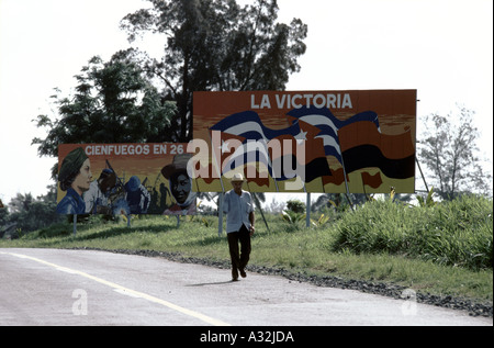 Amputierte Veteran der kubanischen Revolution geht vorbei an "La Victoria" Plakate in Kuba Stockfoto