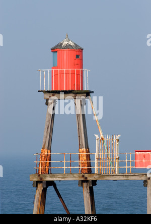 Roter Leuchtturm aus Holz auf Holzbeinen gebaut, mit weißem Sicherheitszaun am East Pier whitby North yorkshire england großbritannien Stockfoto