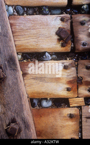 Detail von Meer Verteidigung Buhne Hölzern verschraubt in Form eine abfallende Holzwand mit Kieselsteinen in Risse durch die Kraft des Meeres eingeklemmt Stockfoto