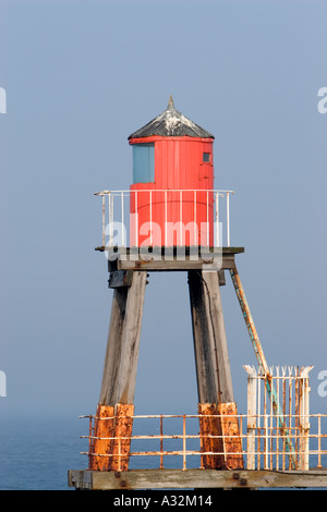 Roter Leuchtturm aus Holz auf Holzbeinen gebaut, mit weißem Sicherheitszaun am East Pier whitby North yorkshire england großbritannien Stockfoto