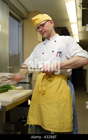 Der Koch und Küchenchef Stefan Voege in der Großküche, wenn sein Messer schärfen Stockfoto