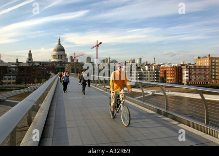 Radfahrer über die Millennium Brücke mit Blick auf St. Pauls Kathedrale hinter Stockfoto