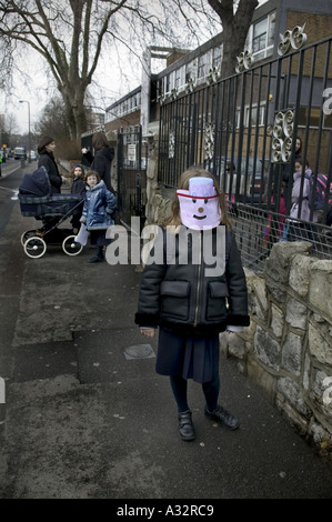 ein junges Mädchen mit einer Maske auf außerhalb ihrer Schule auf dem jüdischen Orthodoxen Purim-Festival London Stockfoto