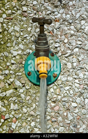 ein outdoor Wasserhahn links laufen, Wasserverschwendung Stockfoto