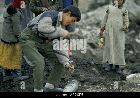 Tod zu riskieren: ein Junge versucht, die Blaskapelle aus einer live Bombe in Diyana Frühling, Irak-Kurdistan zu entfernen. Stockfoto