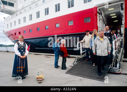 Mädchen in eine traditionelle Tracht begrüßt Touristen, Stokmarknes, Norwegen Stockfoto