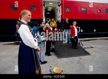 Mädchen in eine traditionelle Tracht begrüßt Touristen, Stokmarknes, Norwegen Stockfoto