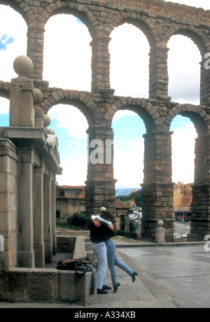 Mit einem alten römischen Aquädukt im Hintergrund küsst ein junges Paar in Segovia Spanien Stockfoto