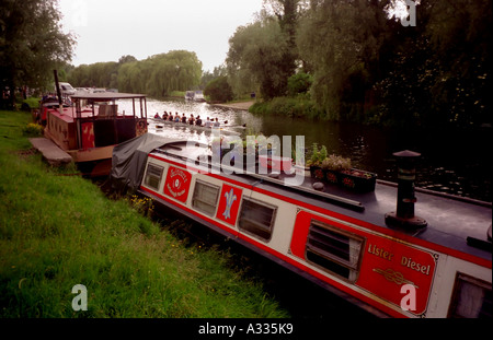 Ruderer auf Besatzung Hochschulteam Womens Reihe vorbei Hausboote auf dem Fluss Cam in Cambridge England Stockfoto