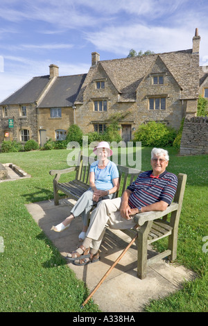 Besucher, die den frühen Abendsonnen im Cotswold Dorf Guiting Power, Gloucestershire, Großbritannien, genießen Stockfoto