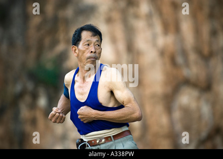 Senior führt vor der Morgendämmerung Tai Chi Übungen im City Park, Geju, Honghe County, Provinz Yunnan, China. Stockfoto