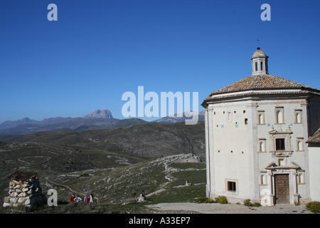 Touristen bei Kapelle in Rocca di Calascio hochkant Campo Imperatore und Corno Grande im Gran Sasso Nationalpark Abruzzen Italien Stockfoto