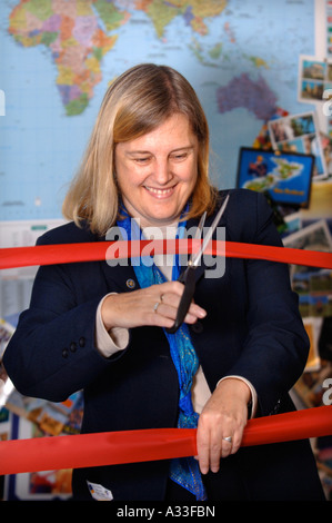 DER BESITZER EINES KLEINEN UNABHÄNGIGEN REISEBÜROS SCHNEIDET EINE BÜROKRATIE-UK Stockfoto