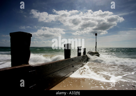 Die Wellen über den Strand Strand groyne Barrieren an Avon Christchurch England brechen Stockfoto