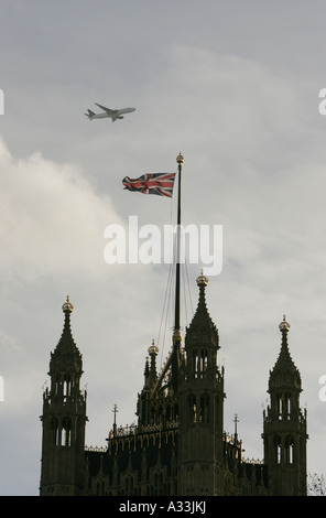 ein Flugzeug fliegt über die Häuser der Victoria Turm Parlamentsgebäude in London england Stockfoto