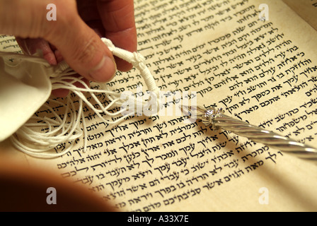 Hebräisch-Tora-Rolle mit Silber Yad (Zeiger) und Gebetsschal (Tallit) auf hebräischen Buchstaben und Wort Stockfoto