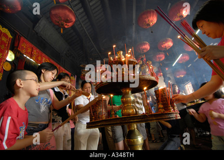 Anbeter Licht Weihrauch von Kerzen zu Kuan Yin Teng Tempel, Georgetown, Penang, Malaysia Stockfoto