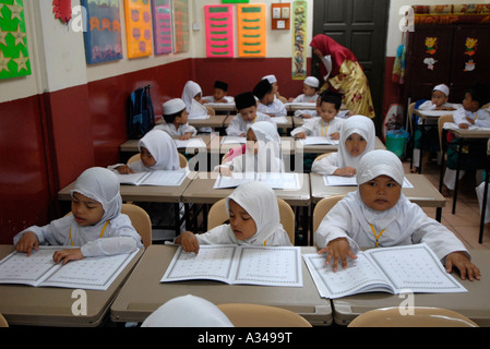 Primäre und Kindergarten Studierende eine vereinfachte Version des Koran an einer islamischen Schule, Kuala Lumpur, Malaysia Stockfoto