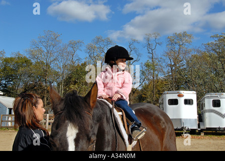 Drei Jahre altes Mädchen reiten eine Pferd Mutter führt Stanhope Ställe Huntington NY Stockfoto