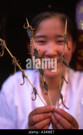 Eine Mädchen zeigt Skorpion Snacks auf dem Stick Peking China Stockfoto