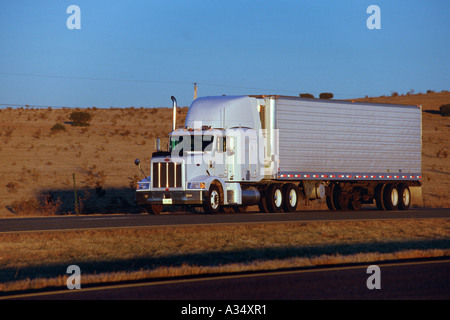 Fernverkehrs-Lkw bei Sonnenuntergang auf der Interstate 40 die moderne Autobahn-Version der historischen Route 66 in der Nähe von Santa Rosa New Mexico USA Stockfoto