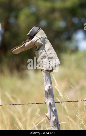 Eine Tradition in den Westen ausrangierten Cowboystiefel Dreh auf einer alten Zaunpfahl Stockfoto