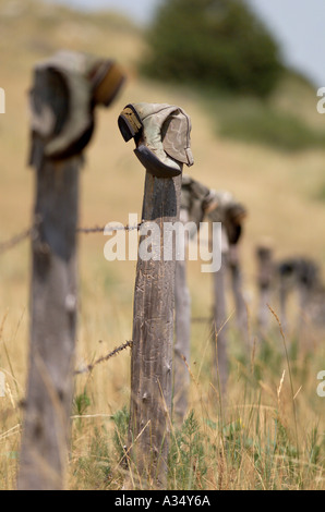 Eine Tradition in den Westen ausrangierten Cowboystiefel Dreh auf einer alten Zaunpfahl Stockfoto