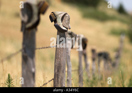 Eine Tradition in den Westen ausrangierten Cowboystiefel Dreh auf einer alten Zaunpfahl Stockfoto