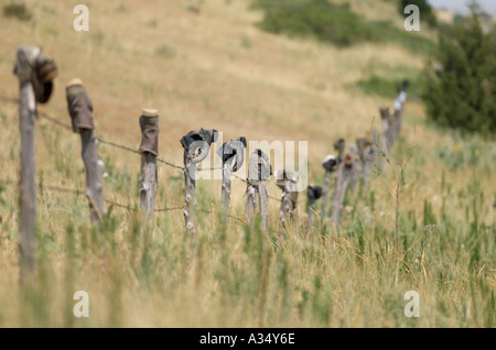 Eine Tradition in den Westen ausrangierten Cowboystiefel Dreh auf einer alten Zaunpfahl Stockfoto