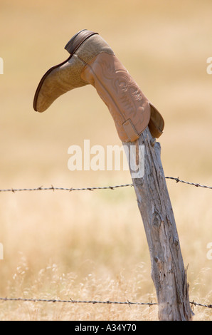 Eine Tradition in den Westen ausrangierten Cowboystiefel Dreh auf einer alten Zaunpfahl Stockfoto