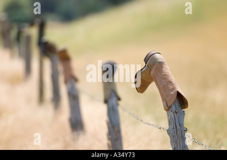 Eine Tradition in den Westen ausrangierten Cowboystiefel Dreh auf einer alten Zaunpfahl Stockfoto