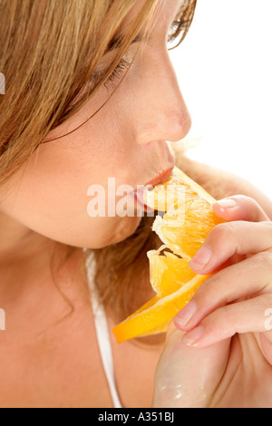 Junge Frau Orangenscheibe beißen Stockfoto