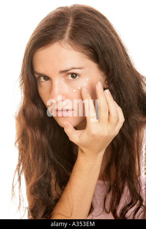 Junge Frau Augencreme aufsetzen Stockfoto