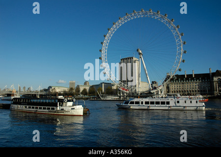 Zwei Boote auf der Themse vorbei am London Eye Riesenrad und County Hall Stockfoto