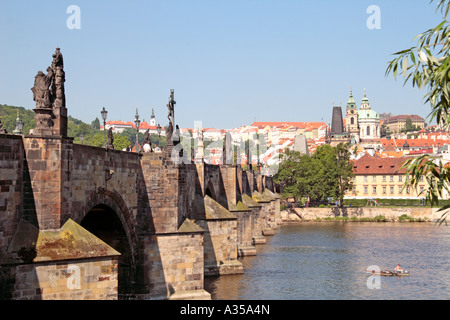 Karlsbrücke über die Moldau, Prag, mit Mann Angeln vom Boot im Vordergrund Stockfoto