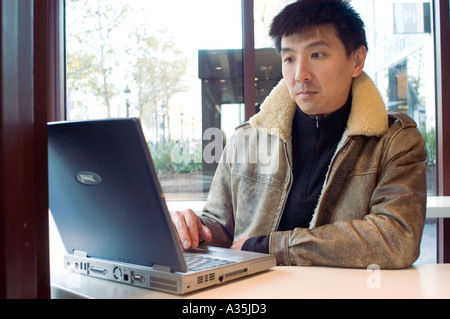 Chinesischer Mann auf Laptop-Bildschirm, im McDonald's Restaurant, paris McDonald's Restaurant, MacDonald's france Stockfoto