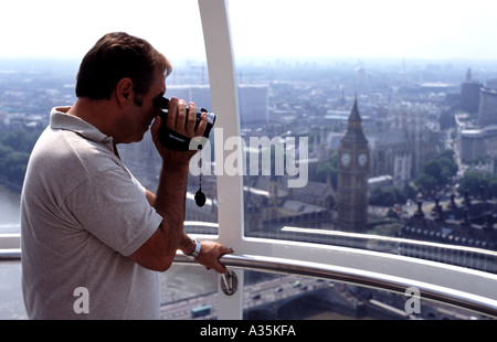 Mann mit Videokamera auf dem London Eye, London, UK. Stockfoto