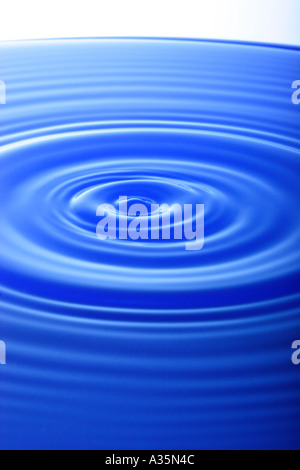 Tropfen Wasser macht Wellen auf der Wasseroberfläche Stockfoto