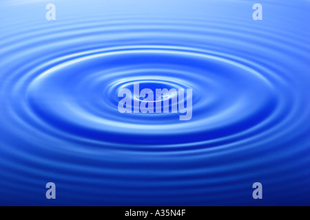 Tropfen Wasser macht Wellen auf der Wasseroberfläche Stockfoto