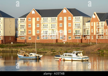 Moderne Mehrfamilienhäuser mit Blick auf Cardiff Bay Waterfront im frühen Morgenlicht mit festgemachten Boote Stockfoto