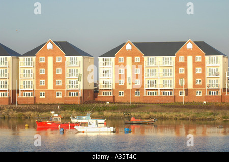 Moderne Mehrfamilienhäuser mit Blick auf Cardiff Bay Waterfront im frühen Morgenlicht mit festgemachten Boote Stockfoto