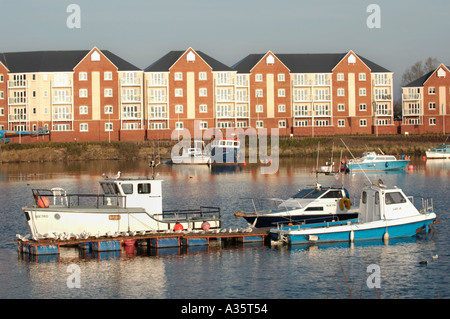 Moderne Mehrfamilienhäuser mit Blick auf Cardiff Bay Waterfront im frühen Morgenlicht mit festgemachten Boote Stockfoto