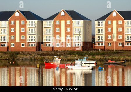 Moderne Mehrfamilienhäuser mit Blick auf Cardiff Bay Waterfront im frühen Morgenlicht mit festgemachten Boote Stockfoto