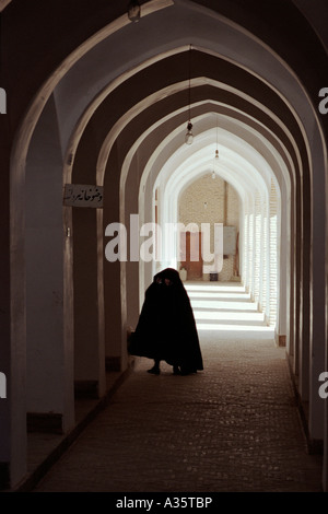 Eine Frau geht durch einen Durchgang in der Jameh Moschee in Yazd, Iran Stockfoto