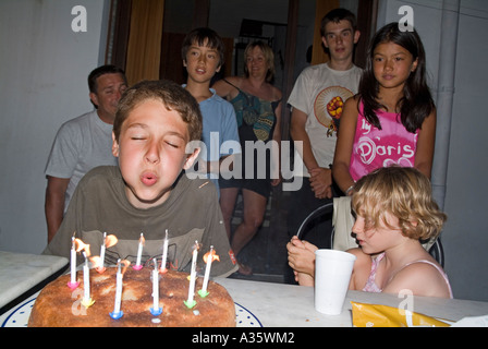 Junge Ausblasen der Kerzen auf seine Geburtstagstorte. Stockfoto