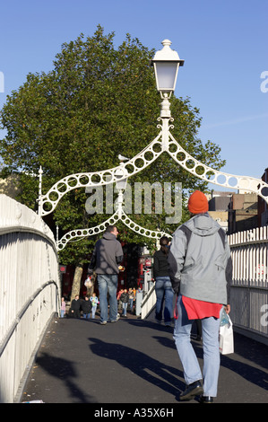 Menschen, die über die Hapenny ha Penny Brücke über den Fluss Liffey in dublin Stockfoto